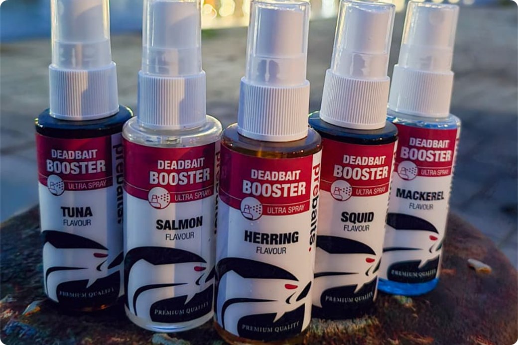 Vijf flesjes baitspray met de aroma's tonijn, zalm, haring, inktvis en makreel op een meerpaal aan het water
